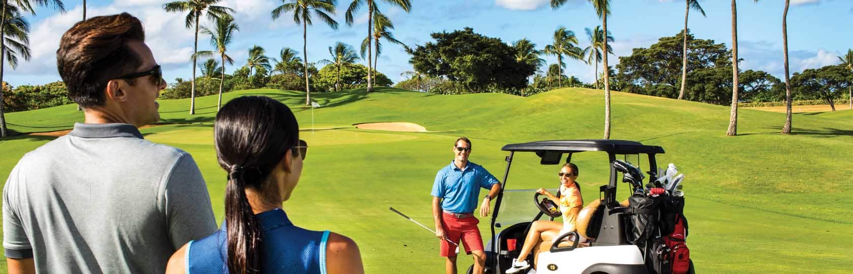 man and woman talking to man and woman on golf cart at golf course
